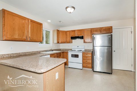 A kitchen with wooden cabinets and a granite countertop.