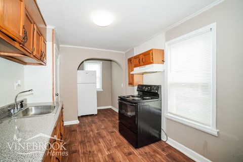 A kitchen with wooden cabinets and a black stove top oven.