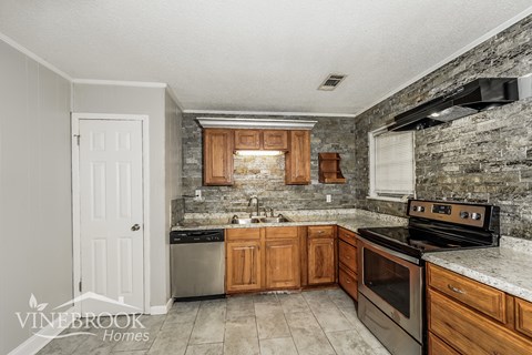 A kitchen with a stove top oven and a sink.