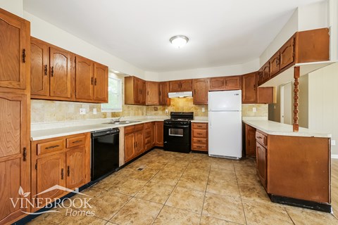 A kitchen with wooden cabinets and appliances.