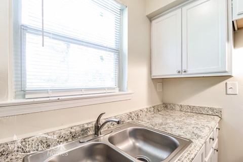 A kitchen with a sink and a window.