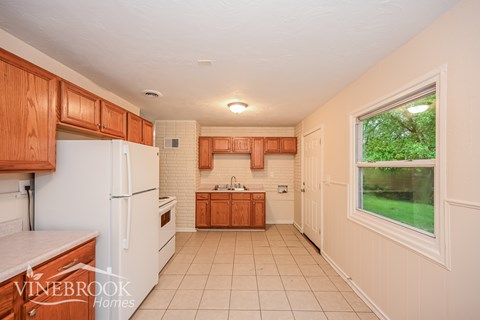 A kitchen with wooden cabinets and a white refrigerator.