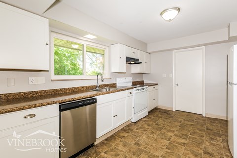 A kitchen with a Vinebrook Homes logo.