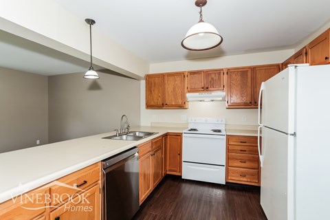 A kitchen with wooden cabinets and white appliances.