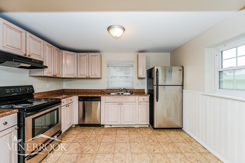 A kitchen with a black stove top oven and a black microwave.