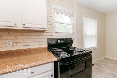 A black stove top oven with four burners is on a kitchen counter.