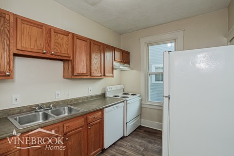 A kitchen with wooden cabinets and a white refrigerator.