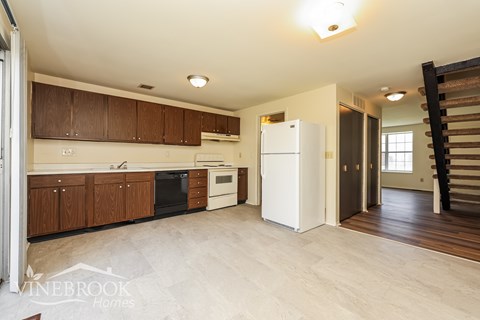 A kitchen with wooden cabinets and a white refrigerator.