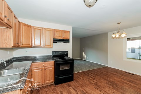 A kitchen with wooden cabinets and a black stove top oven.