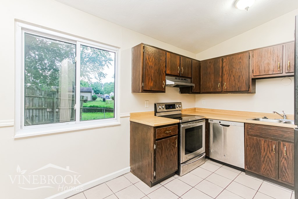 A kitchen with wooden cabinets and stainless steel appliances.