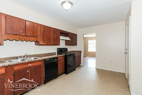 A kitchen with wooden cabinets and black appliances.