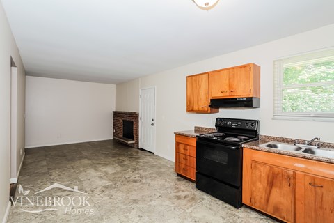 A kitchen with black appliances and wooden cabinets.