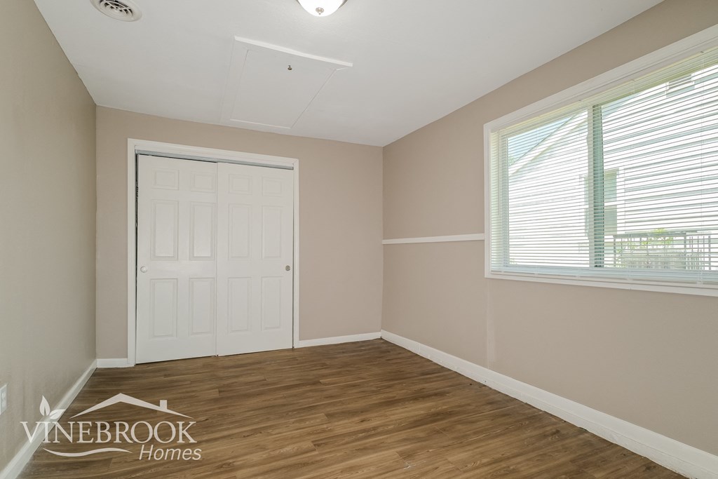 the living room of a home with a wooden floor and a white door