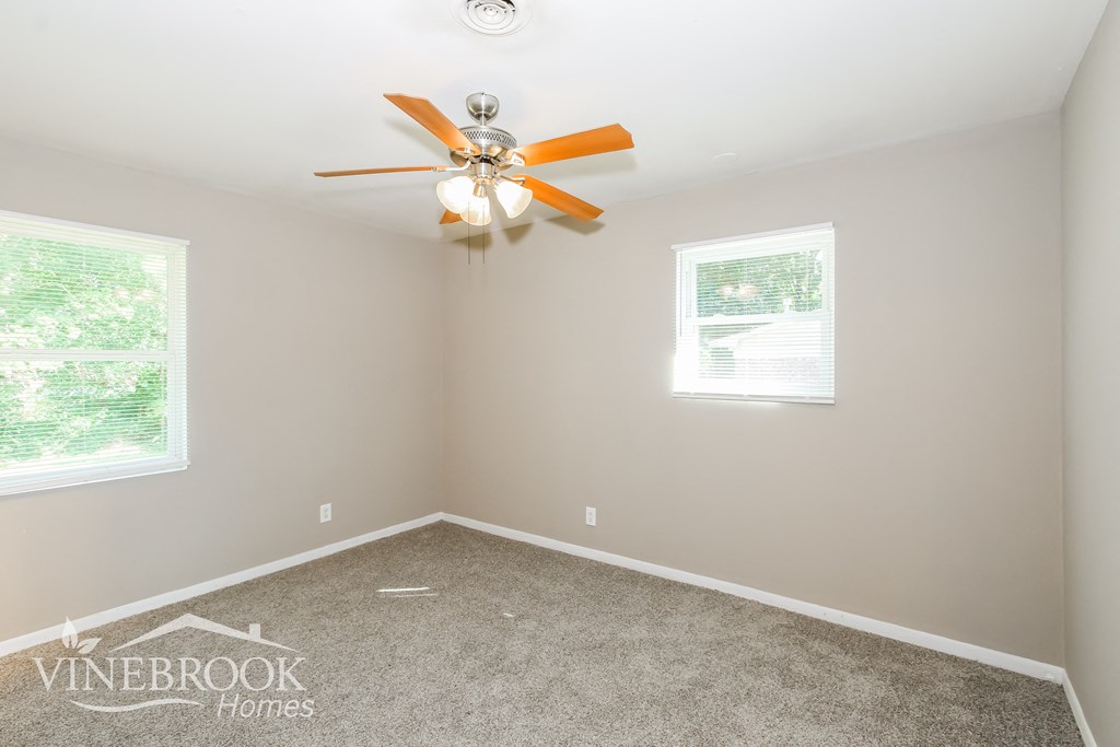 the master bedroom has a carpeted floor and a ceiling fan