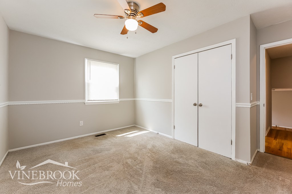 a bedroom with a closet and a ceiling fan