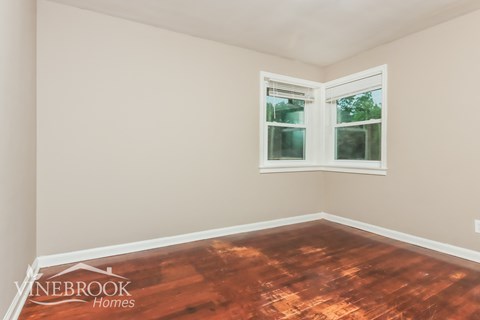 A room with a wooden floor and a window.