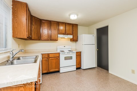 A kitchen with wooden cabinets and white appliances.