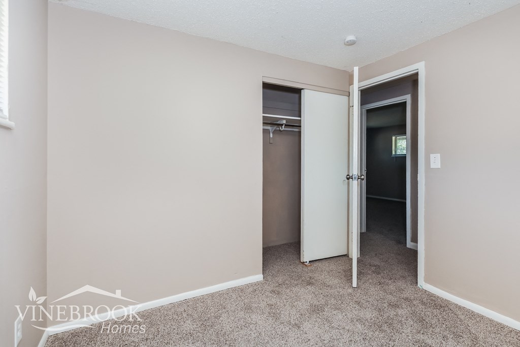 a bedroom with a closet and a door to a bathroom