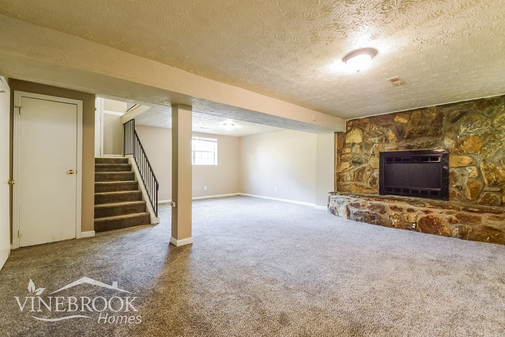 a living room with a fireplace and a stone wall
