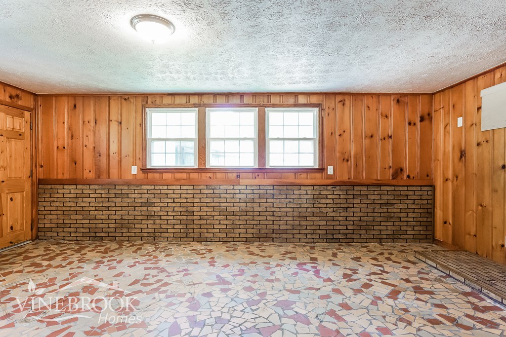a empty room with a brick wall and a window