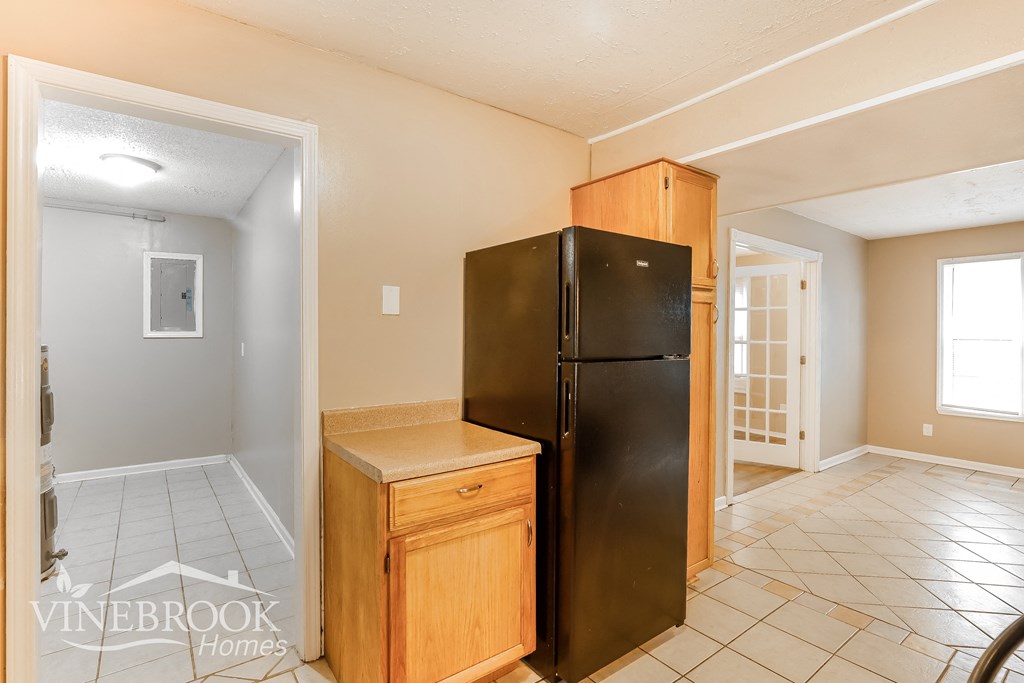 a kitchen with a black refrigerator and a counter top