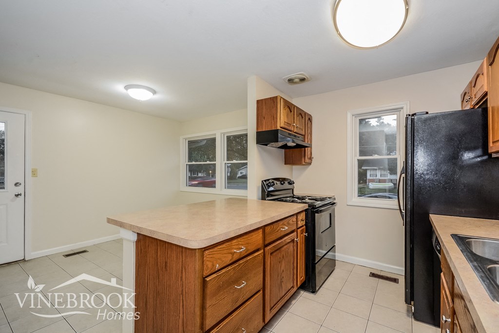 a kitchen with wooden cabinets and black appliances and a counter top