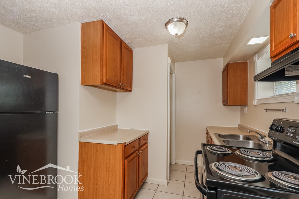 a kitchen with a stove refrigerator and a sink