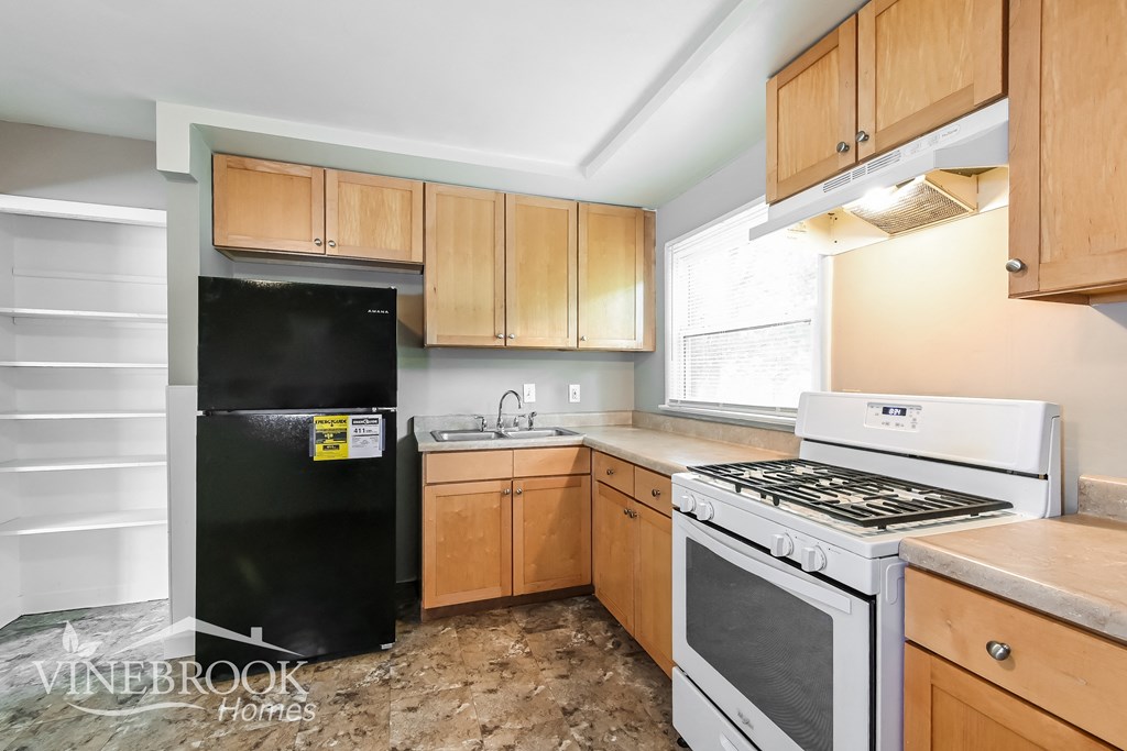 a kitchen with white appliances and wooden cabinets
