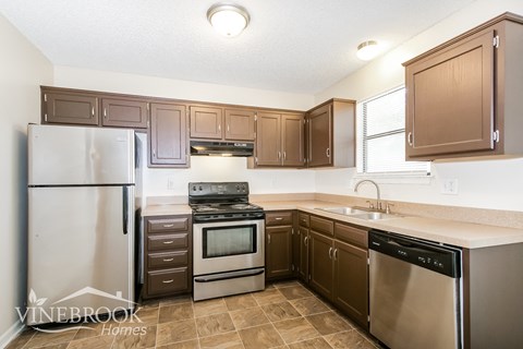 A kitchen with brown cabinets and stainless steel appliances.