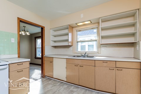 A kitchen with wooden cabinets and a white dishwasher.