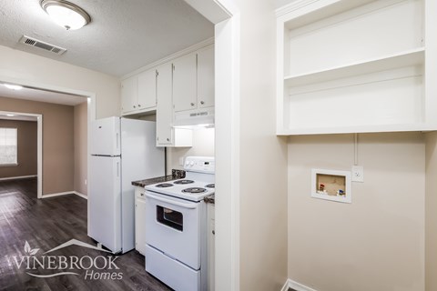 A kitchen with white appliances and cabinets is shown.