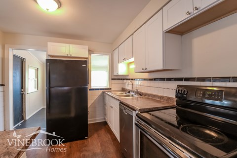 A kitchen with a black refrigerator and stove.