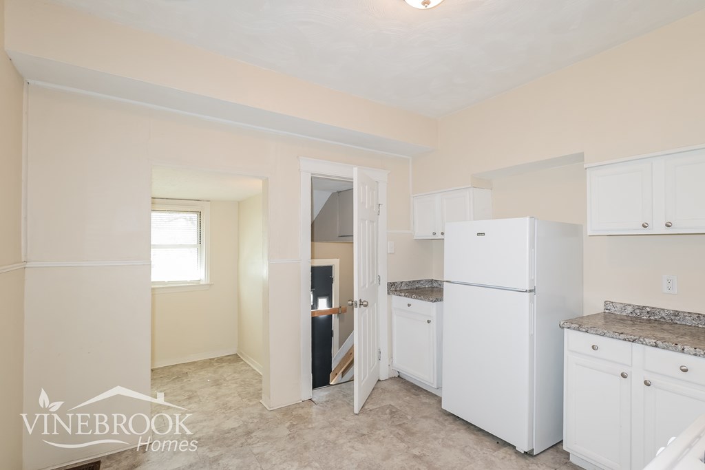A kitchen with white appliances and cabinets is shown.
