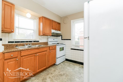 A kitchen with wooden cabinets and a white refrigerator.