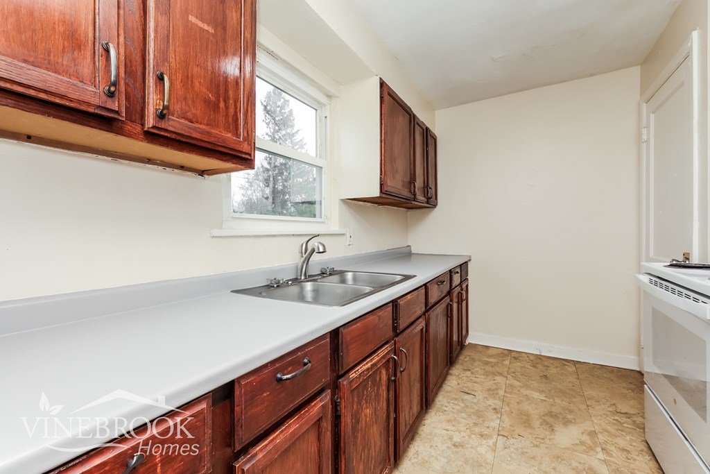 A kitchen with wooden cabinets and a white countertop.