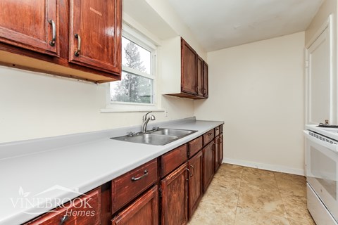 A kitchen with wooden cabinets and a white countertop.