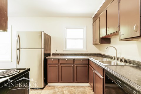 A kitchen with brown cabinets and a black stove top oven.