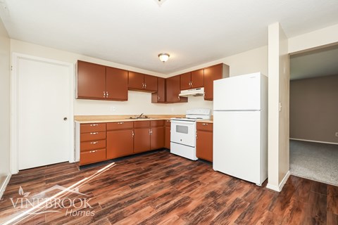 A kitchen with brown cabinets and a white fridge.