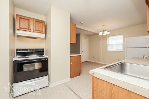 A kitchen with a stove top oven and a sink.