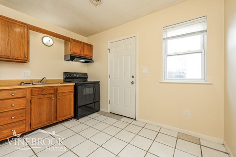 A kitchen with wooden cabinets and a black oven.