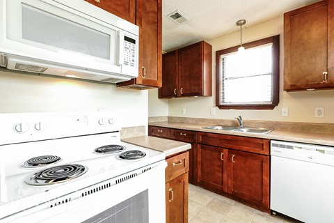 A white stove with a white microwave above it in a kitchen.