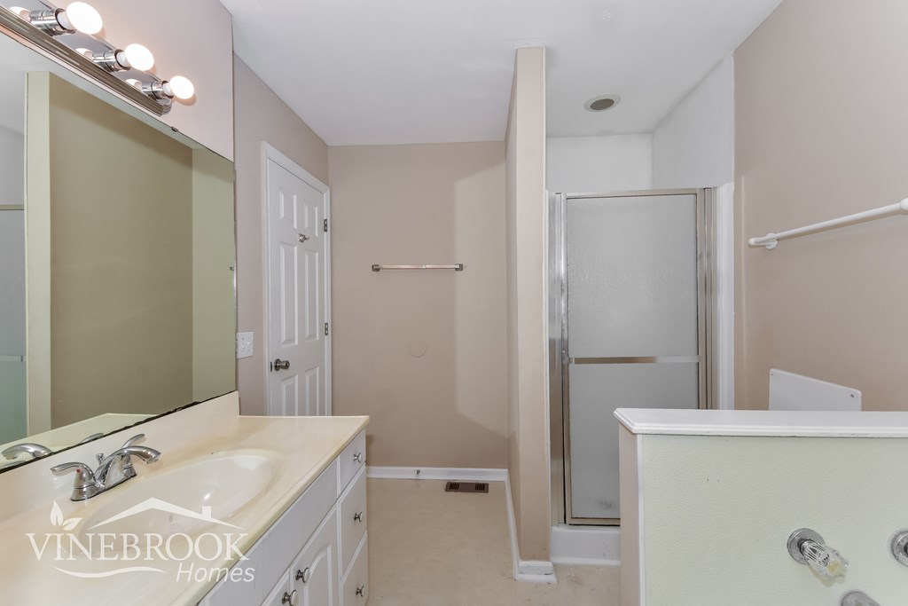 a white bathroom with a sink and a shower