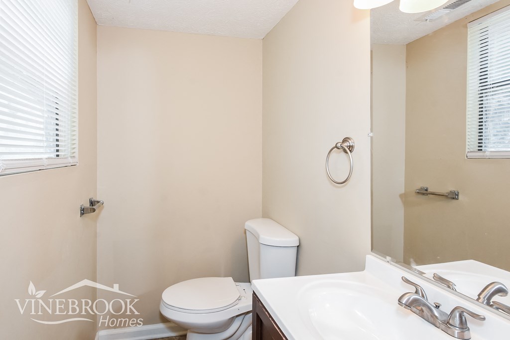 a full bathroom with a toilet sink and mirror and a shower
