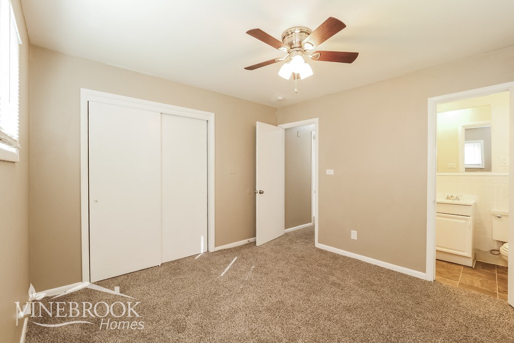 a bedroom with a ceiling fan and a closet