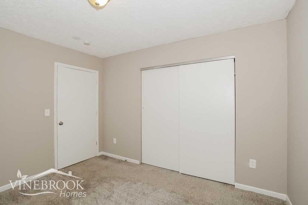 a bedroom with two closets and a carpeted floor