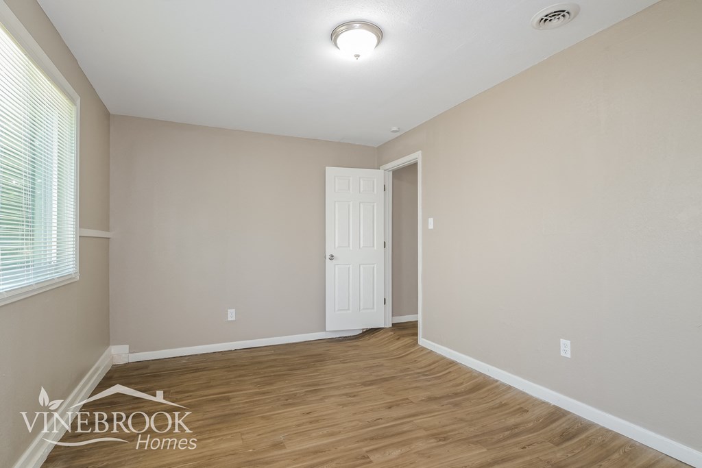 the living room after renovation with wood flooring and a white door