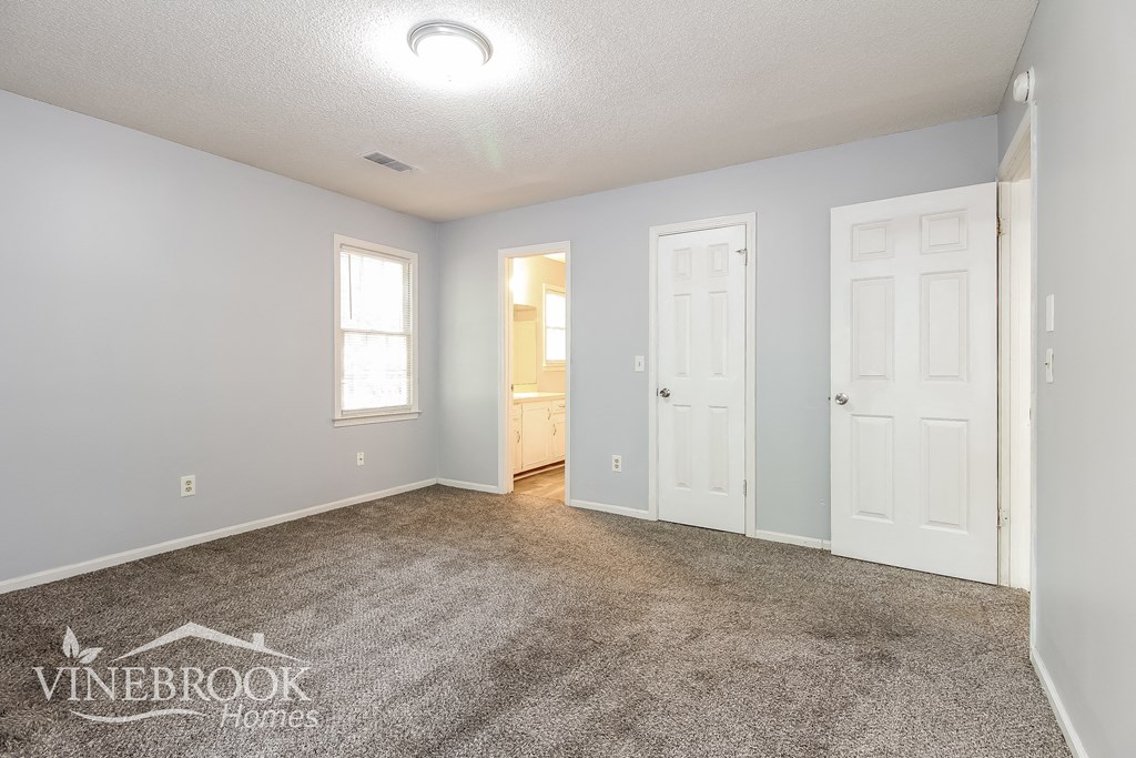 a living room with a carpeted floor and white doors