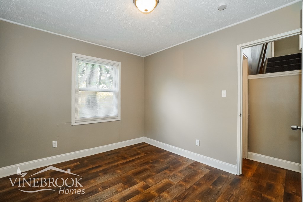 the living room of a house with wood flooring and a door to a closet
