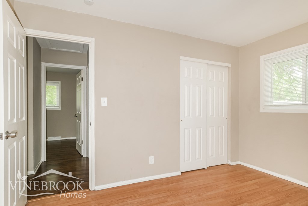 the living room of a home with wooden floors and white doors