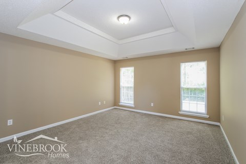the living room of a new home with carpet and windows